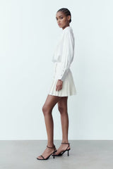 Mini-jupe plissée taille haute à boutons décoratifs