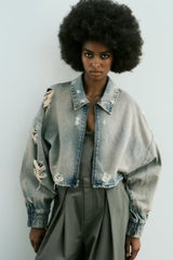 Veste courte en jean à col usé, délavée, perforée et décorée de trous