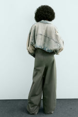 Veste courte en jean à col usé, délavée, perforée et décorée de trous