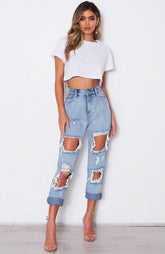 Lockere, verwaschene Denimhose mit hoher Taille und unregelmäßigen, asymmetrischen Rissen