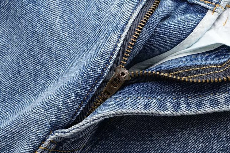 Lässige Hose mit geradem Bein und perforierter Lochdekoration. Lockere Jeans mit mittlerer Taille