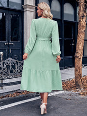 Robe mi-longue à pois et ceinture à surplis et manches bouffantes