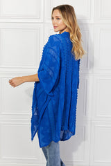 Justin Taylor – Asymmetrischer Poncho-Cardigan mit Pom-Poms in Blau
